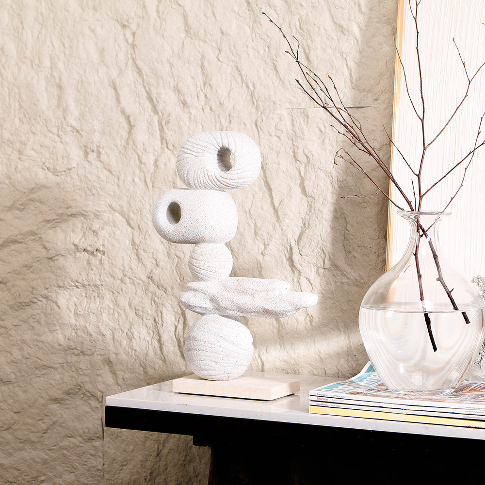 Decorative Modern Abstract sculpture with Stone Stacking Form on a table against a textured wall