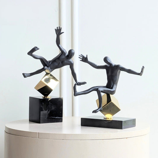Kinesis leaning and reaching metal human showpieces displayed as a pair