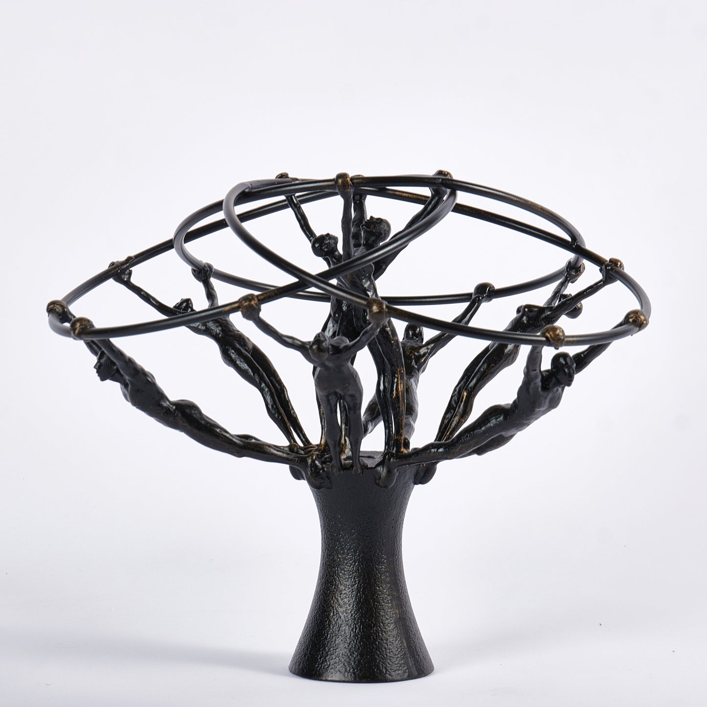 Black metal sculpture with abstract human figures on a white background