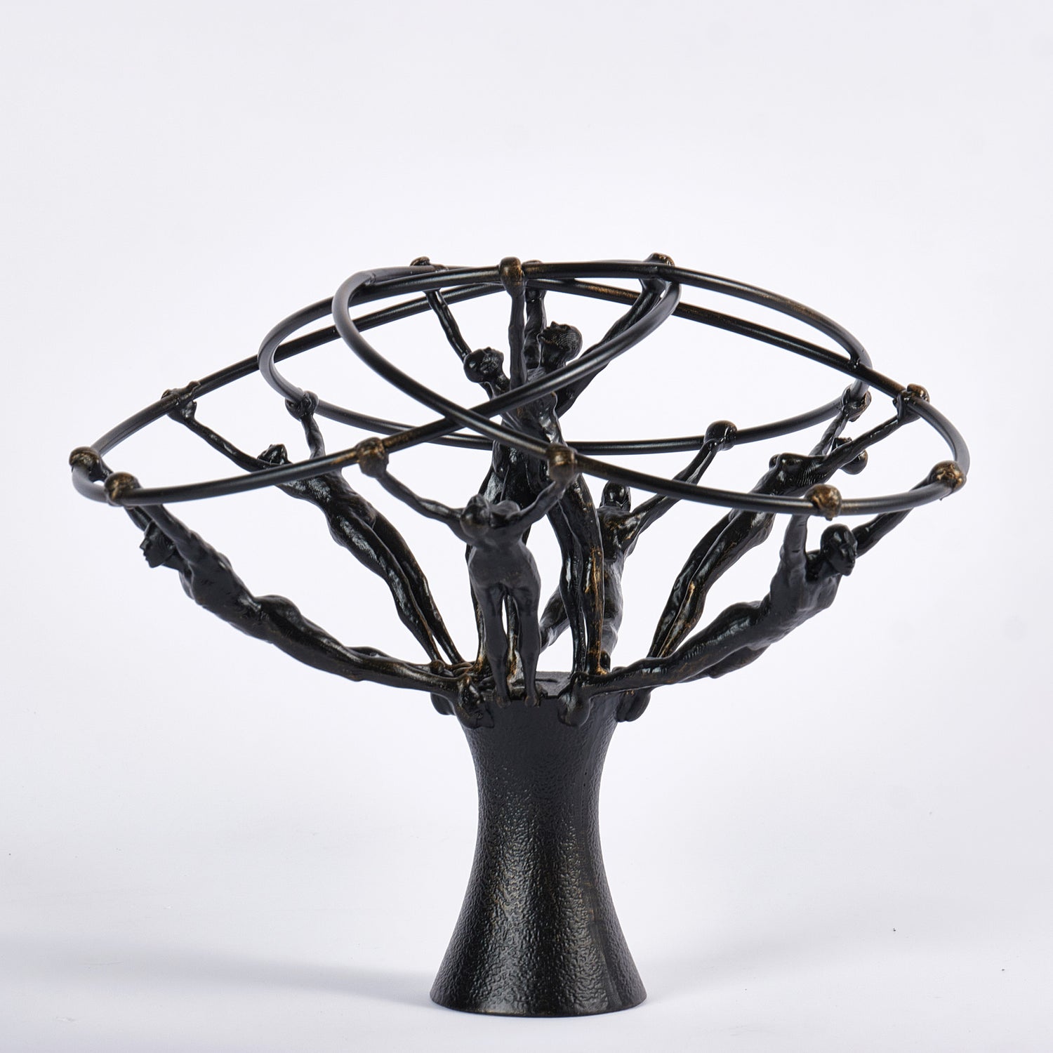 Black metal sculpture with abstract human figures on a white background
