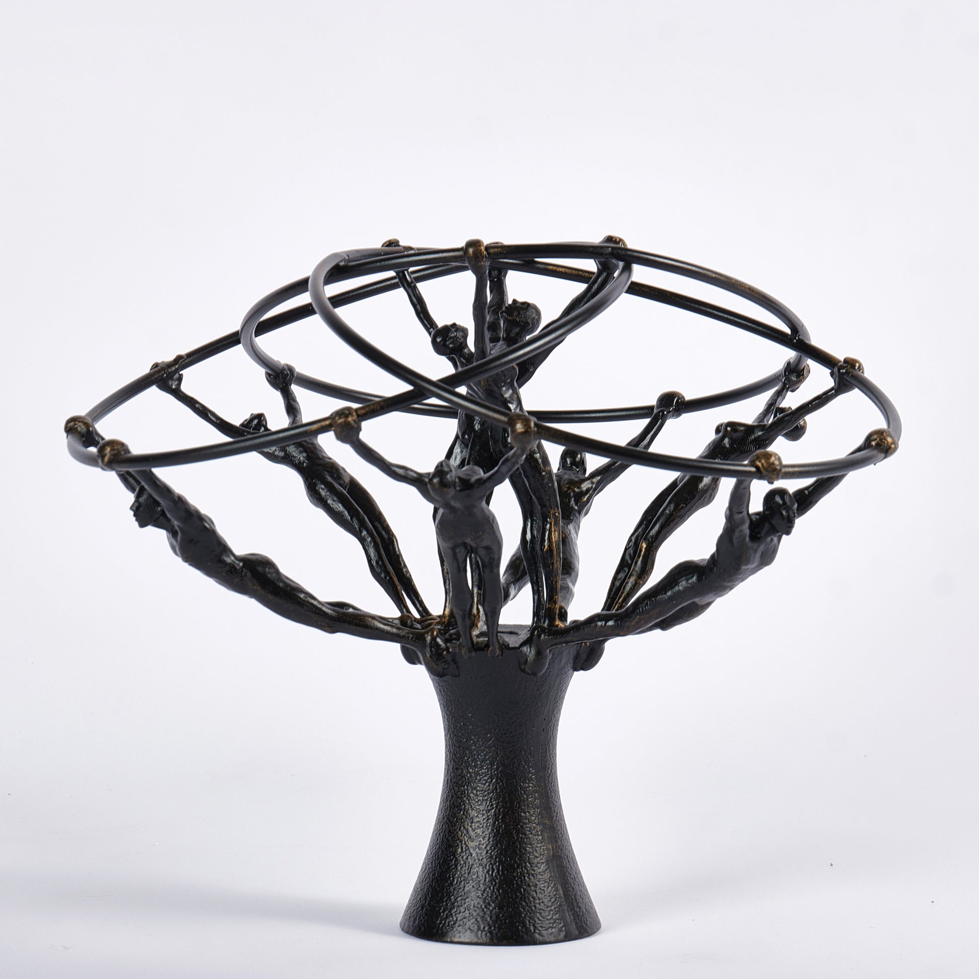 Black metal sculpture with abstract human figures on a white background
