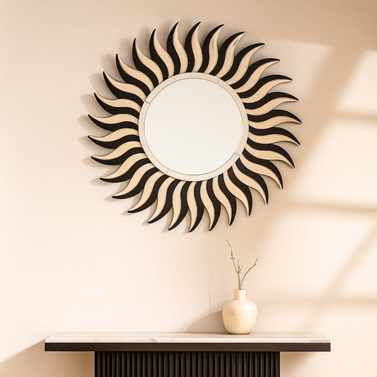 Decorative wall mirror with sunburst design on a beige wall above a console table.