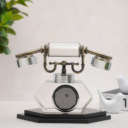 Vintage-style telephone decor on a white surface with a plant in the background