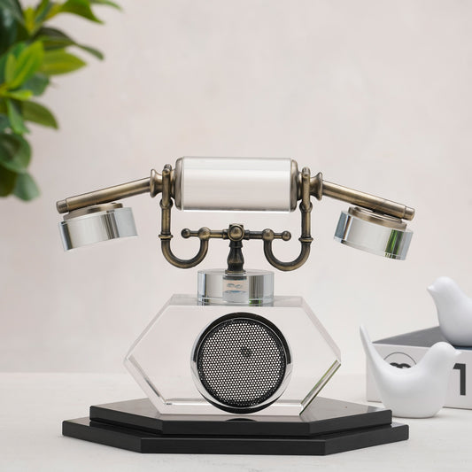 Vintage-style telephone decor on a white surface with a plant in the background