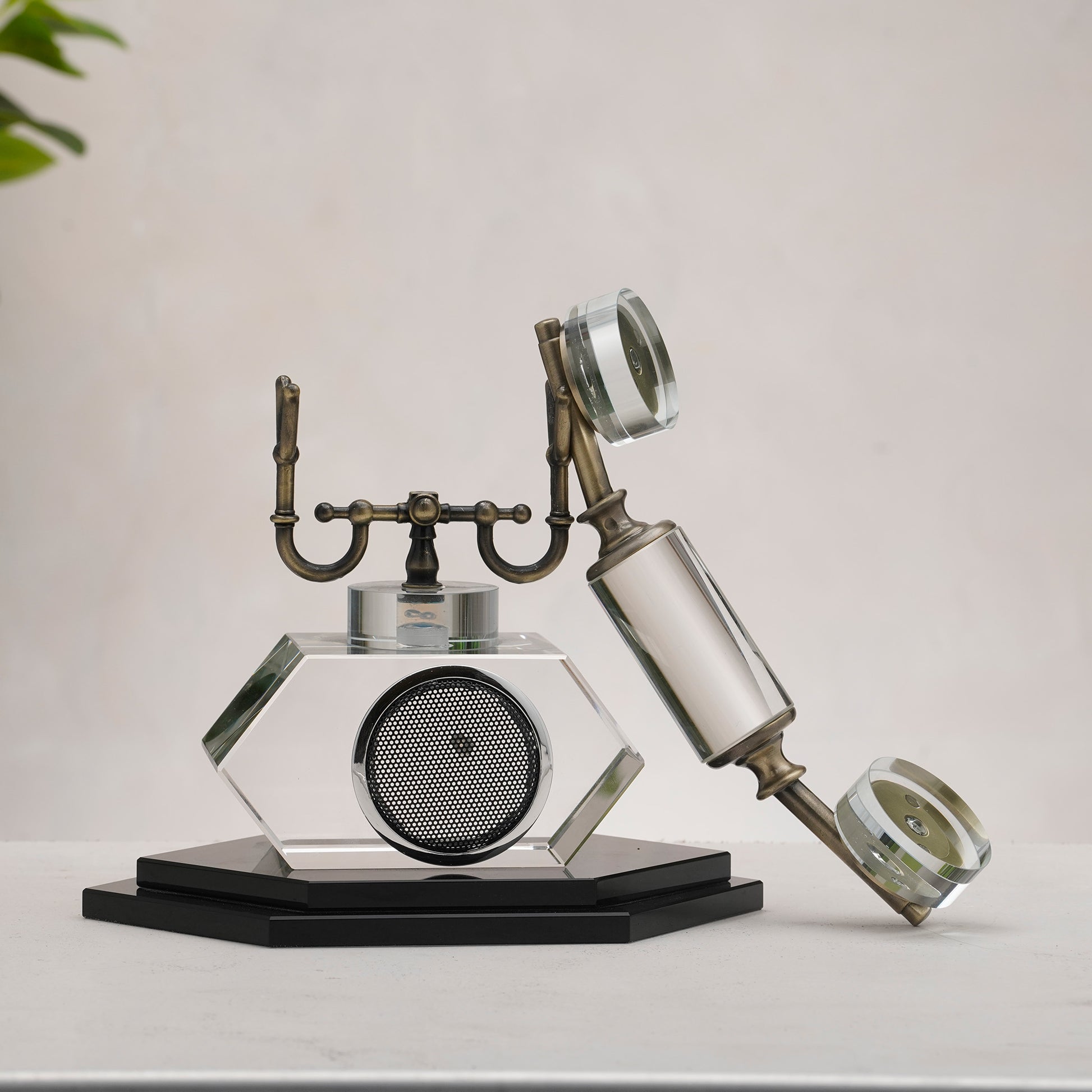 Decorative glass object resembling a vintage phone on a plain background