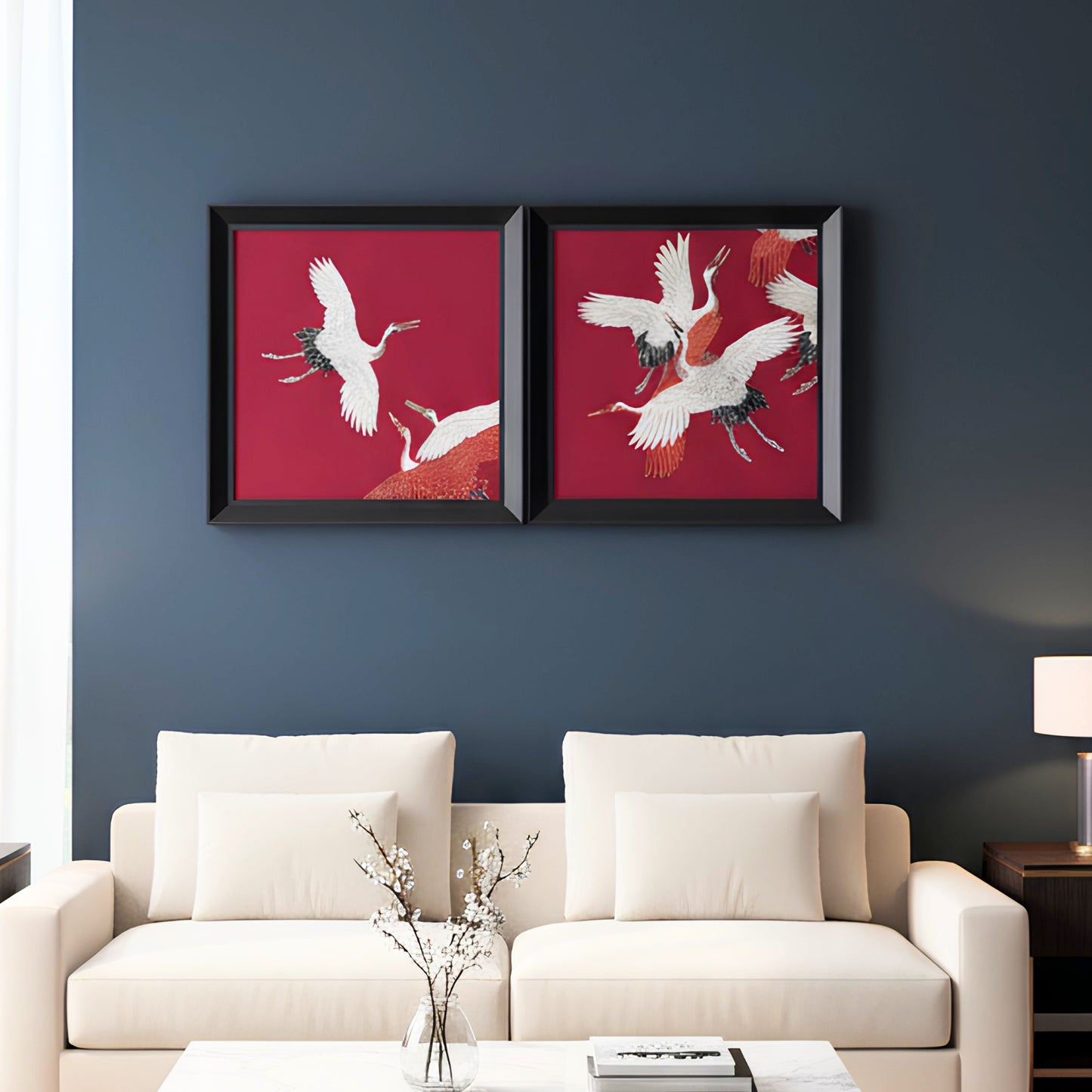 Two framed artworks of cranes on a red background in a living room.