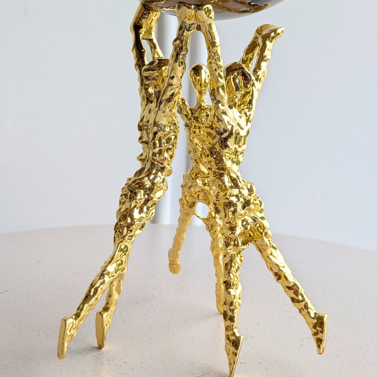 Atlas polished gold human figurines close-up detail