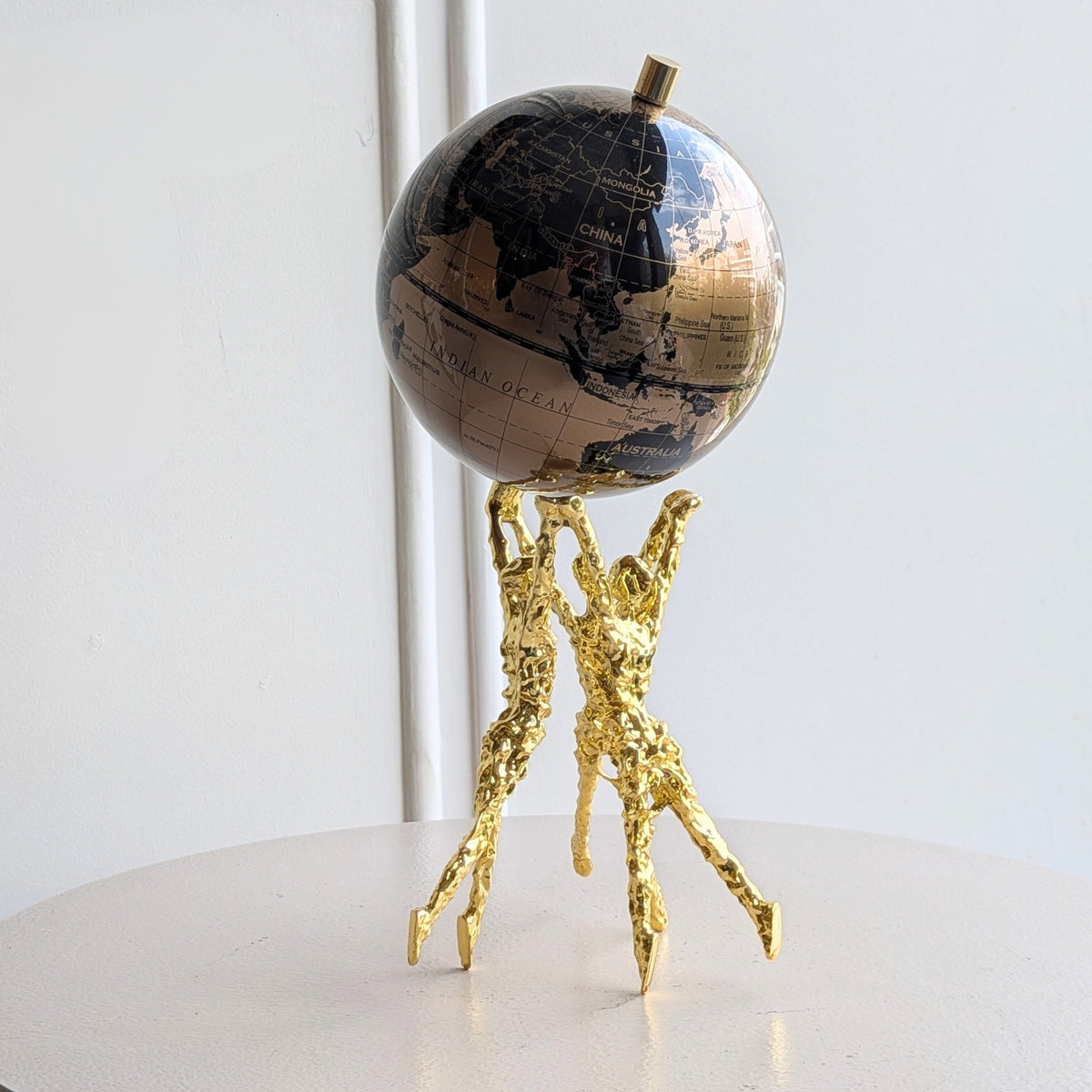 Atlas gold human figurine and globe showpiece angled view