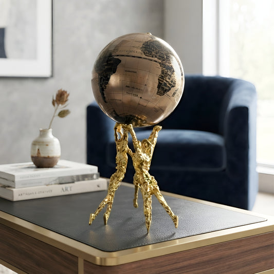 Atlas gold human figurine with globe styled on a study desk