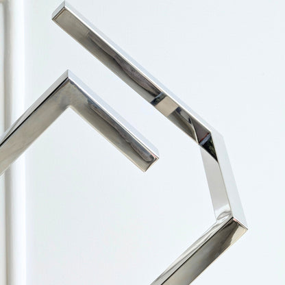 Close-up detail of Axiom polished stainless steel geometric sculpture