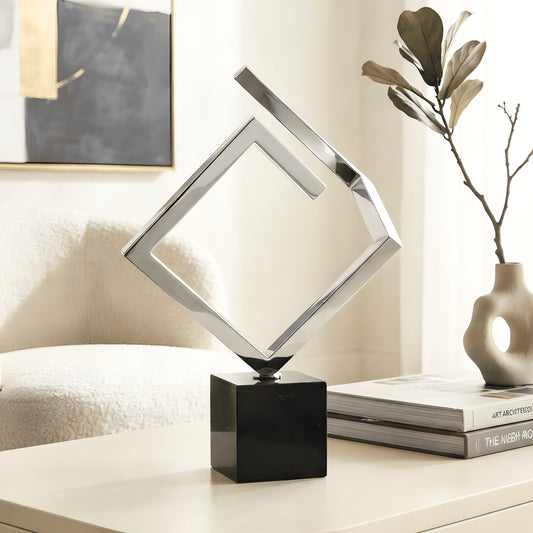 Axiom stainless steel geometric showpiece with black marble base styled in a modern living room