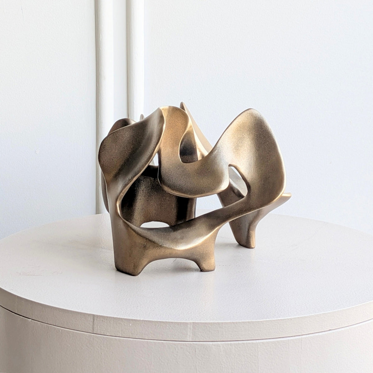 Bronze Modern Abstract Showpiece displayed on a round pedestal table