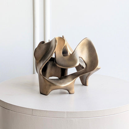 Bronze Modern Abstract Showpiece displayed on a round pedestal table