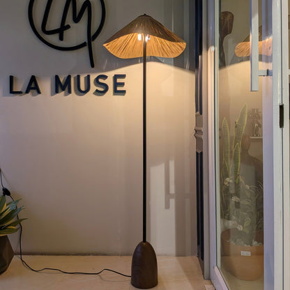 Canopy floor lamp illuminated at the La Muse showroom with a warm ambient glow