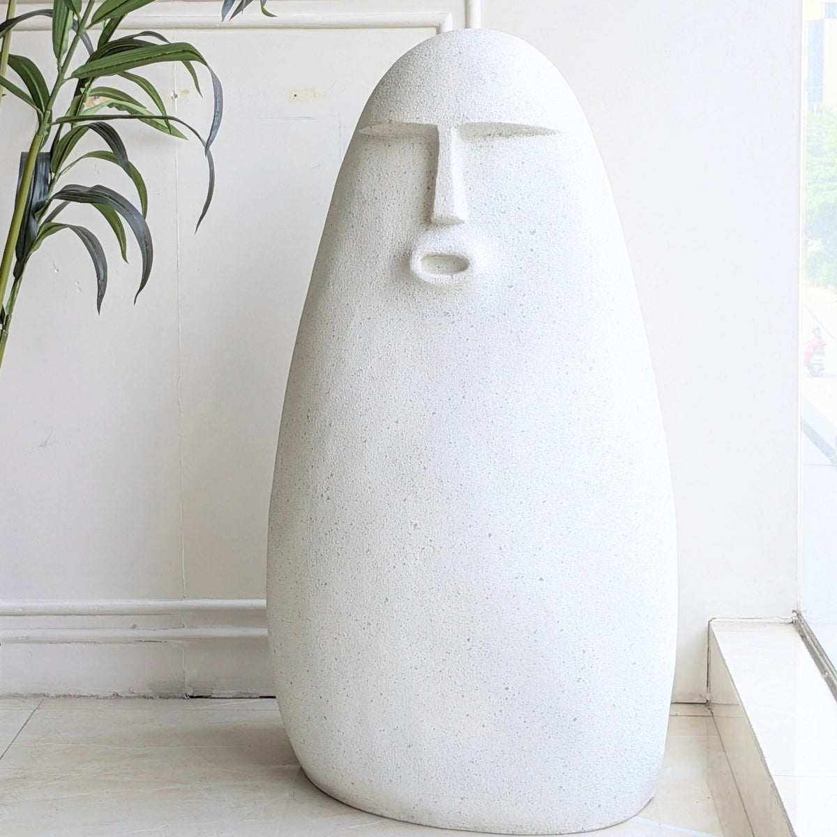 Carven large textured resin floor sculpture with a carved stone finish and abstract human face