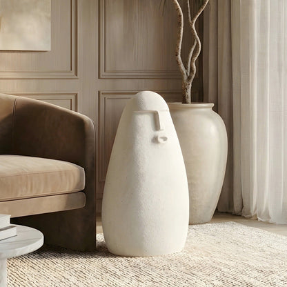 Carven large stone-finish human floor sculpture beside a lounge chair and oversized vase