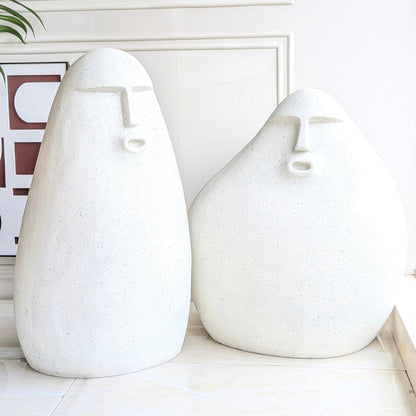 Carven resin human floor sculptures set of two with abstract faces and a carved stone finish