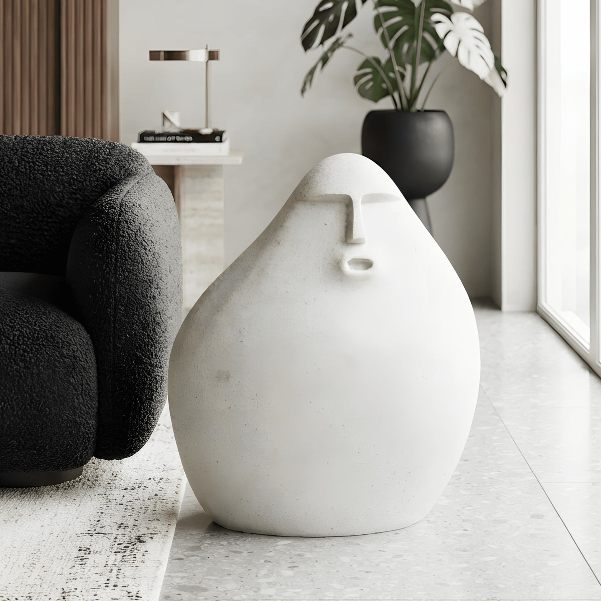 Carven small abstract human floor sculpture styled beside a black reading chair
