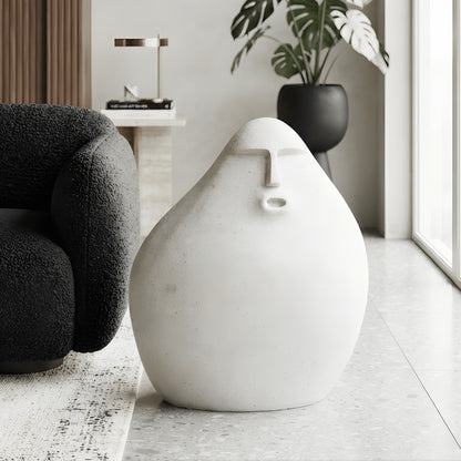 Carven small abstract human floor sculpture styled beside a black reading chair