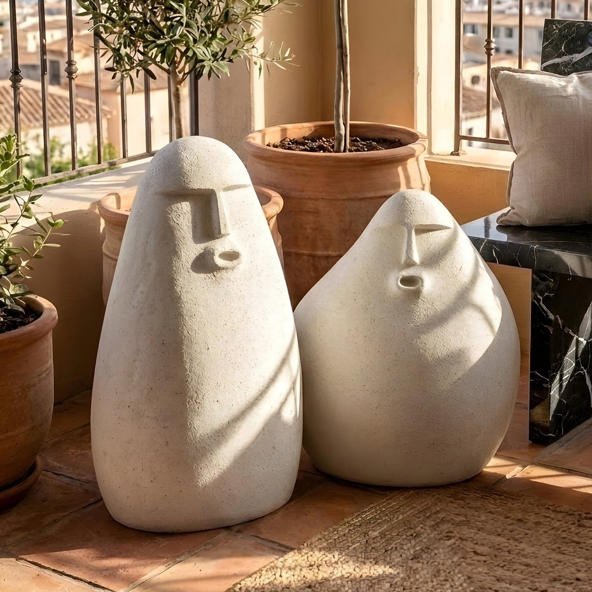 Carven white human floor sculpture pair styled in a warm sunroom with terracotta planters