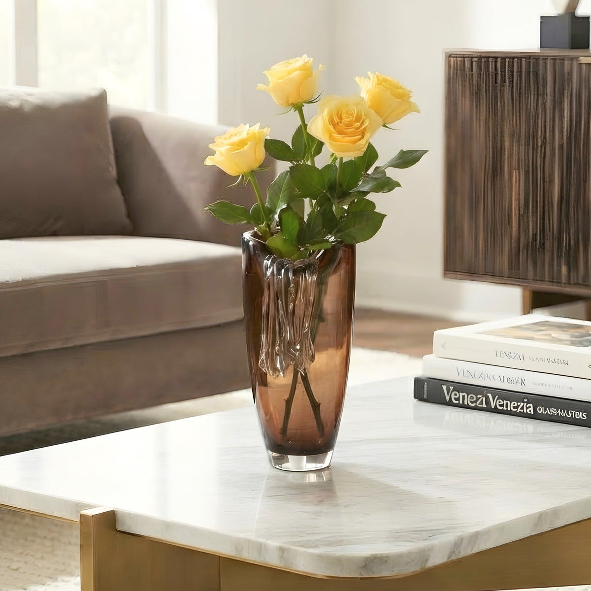 Cascade amber crystal vase with yellow roses on a luxury coffee table