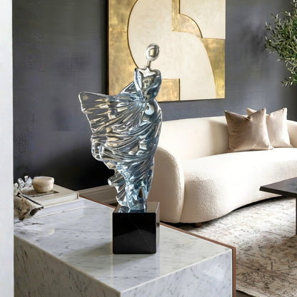 Diva clear blue dancer sculpture styled on a marble console in a contemporary living room