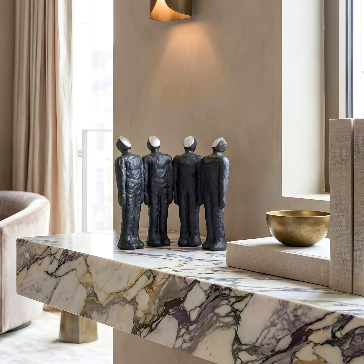 Ensemble four-figure sculptural decor styled on a marble sideboard in a contemporary interior