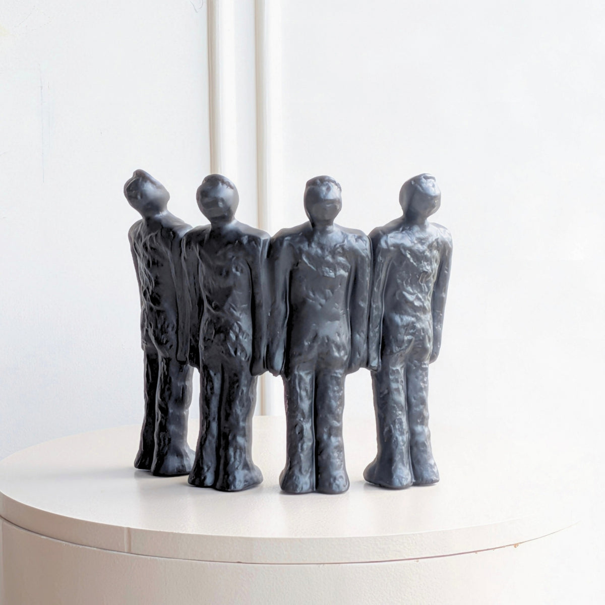 Ensemble textured dark resin human figurine group with four individual forms in one composition