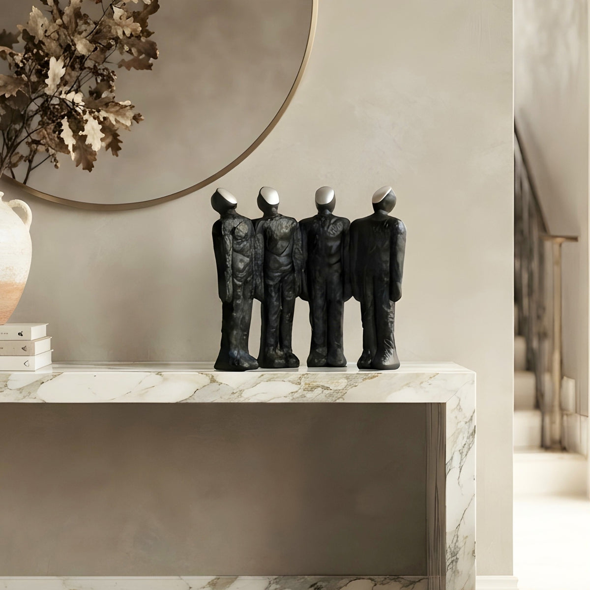 Ensemble four connected human figures as statement decor beneath a round entryway mirror