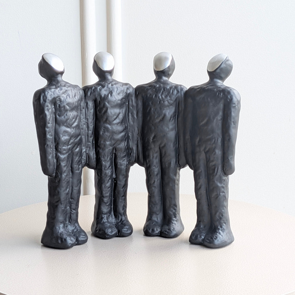 Ensemble charcoal-black abstract resin figurines with sculpted textured finish and pale faces