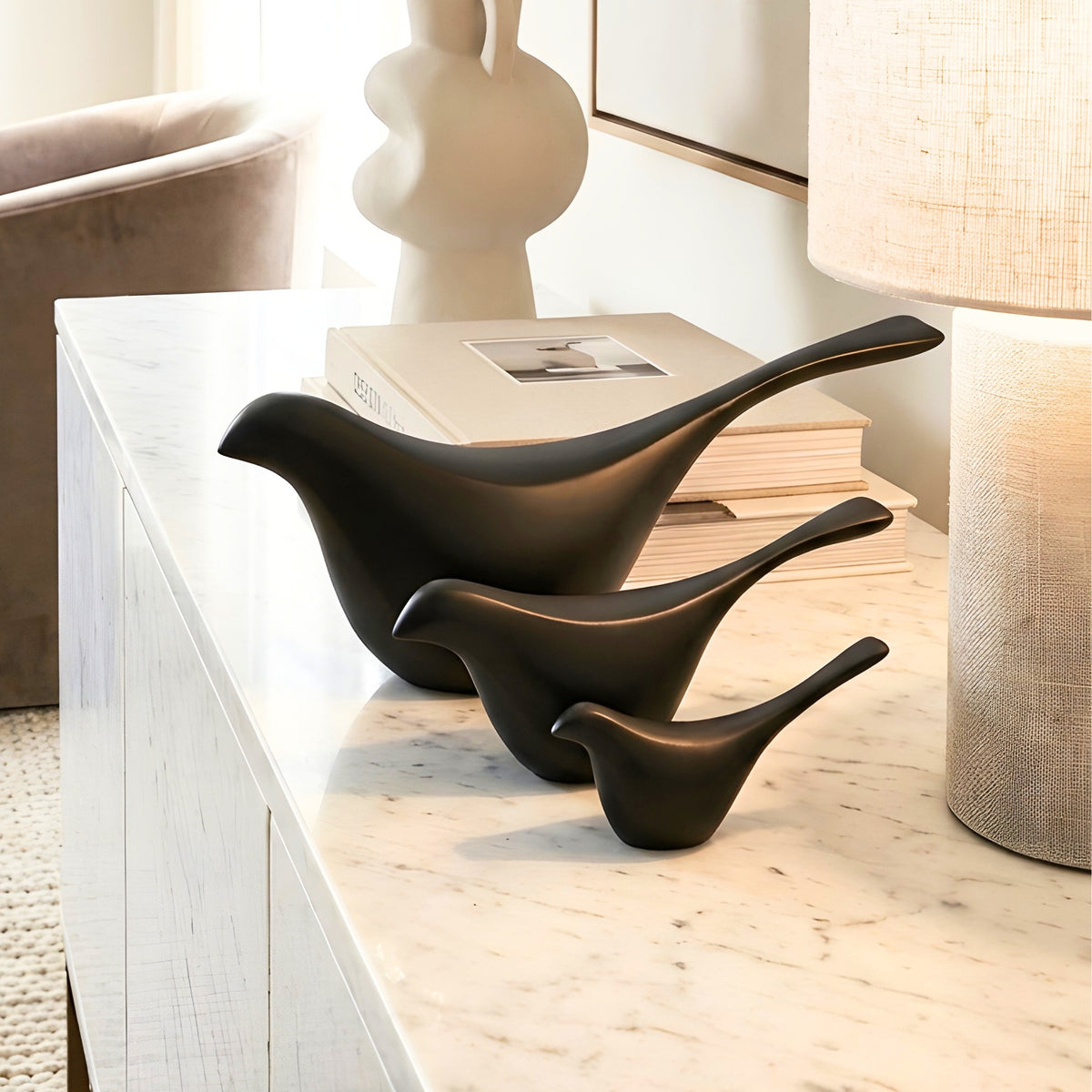 Flock black bird showpieces set of 3 styled on a marble console beside a table lamp