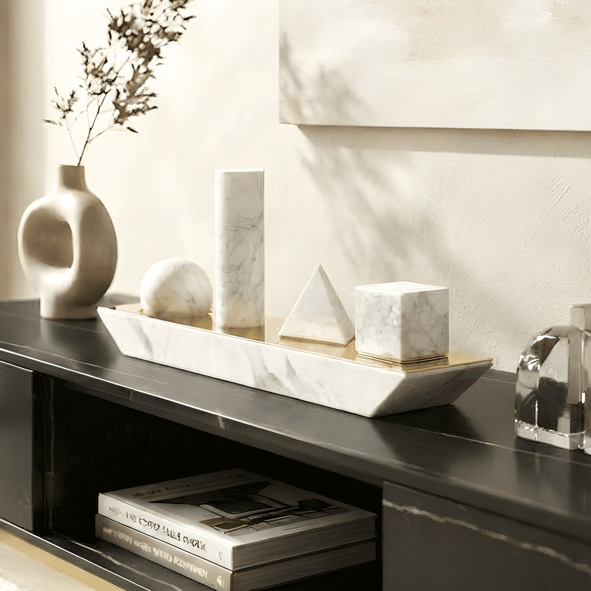 Geometry marble sphere cylinder pyramid and cube sculpture on a black console