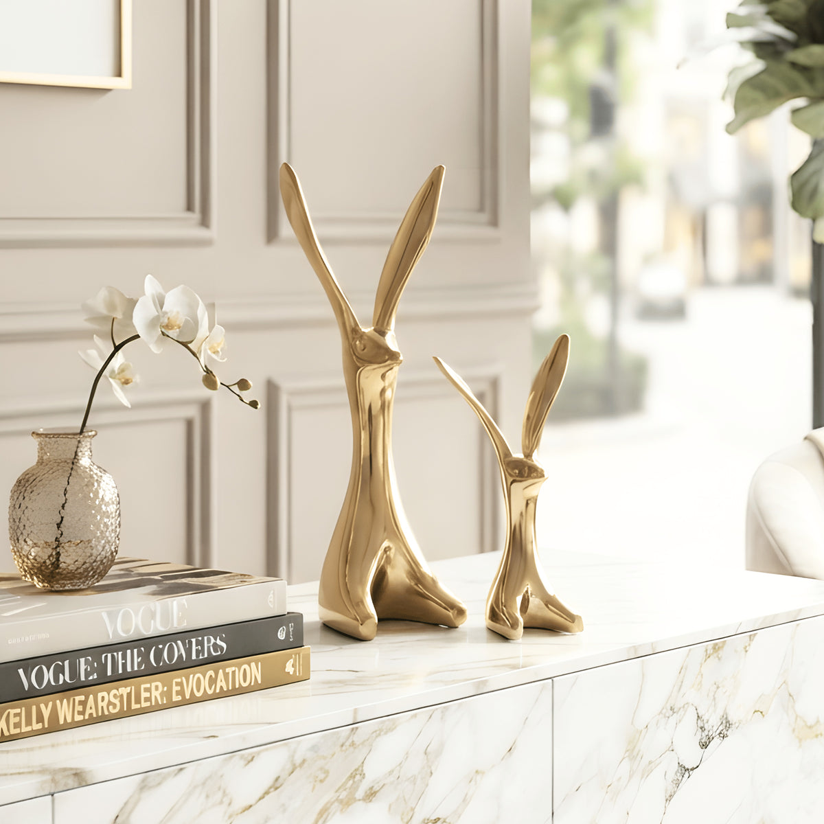 Hareloom large and small gold ceramic rabbit figurines styled together on a luxury living room console table