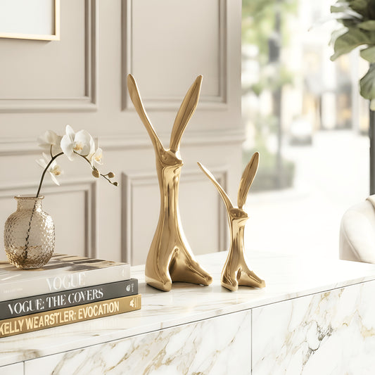 Hareloom large and small gold ceramic rabbit figurines styled together on a luxury living room console table