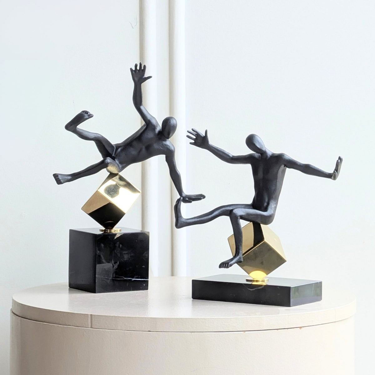 Kinesis leaning and reaching metal human showpieces displayed as a pair