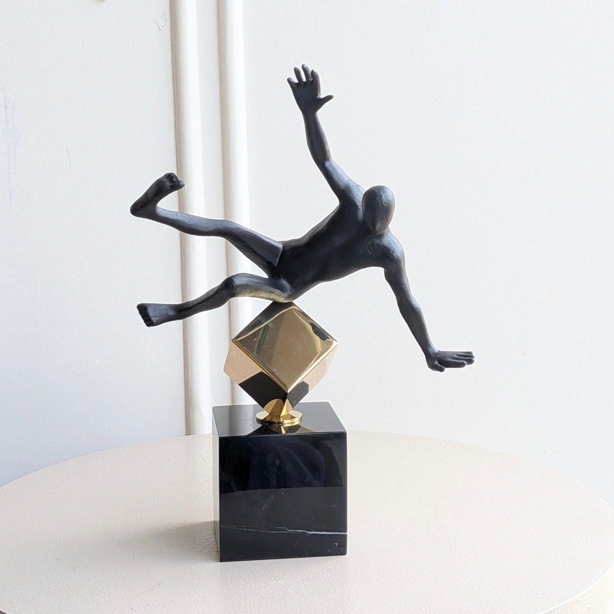 Front view of the Kinesis leaning human showpiece in black and gold metal