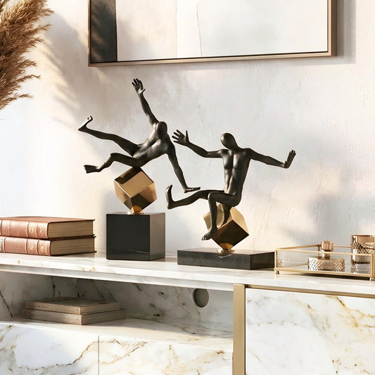 Kinesis black and gold metal human figurines styled together on a console table