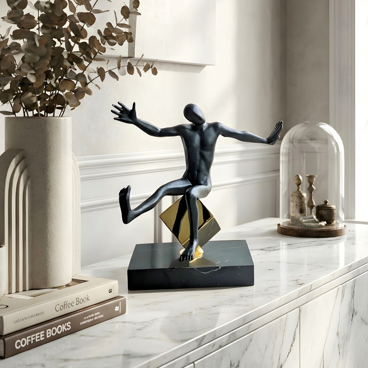 Kinesis reaching metal human figurine styled on a marble console table