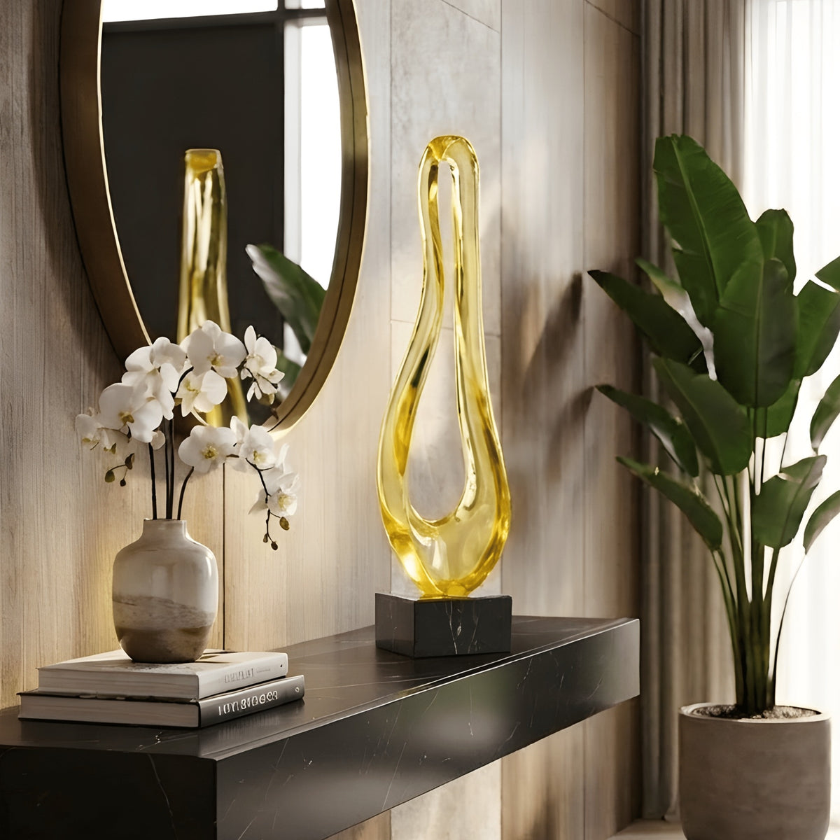 Loop gold resin sculpture on black marble base styled on an entryway console