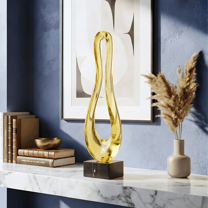 Loop tall gold abstract sculpture styled on a marble sideboard against a blue wall