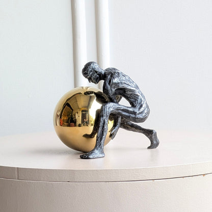 Strive gold orb metal showpiece on a marble living room coffee table