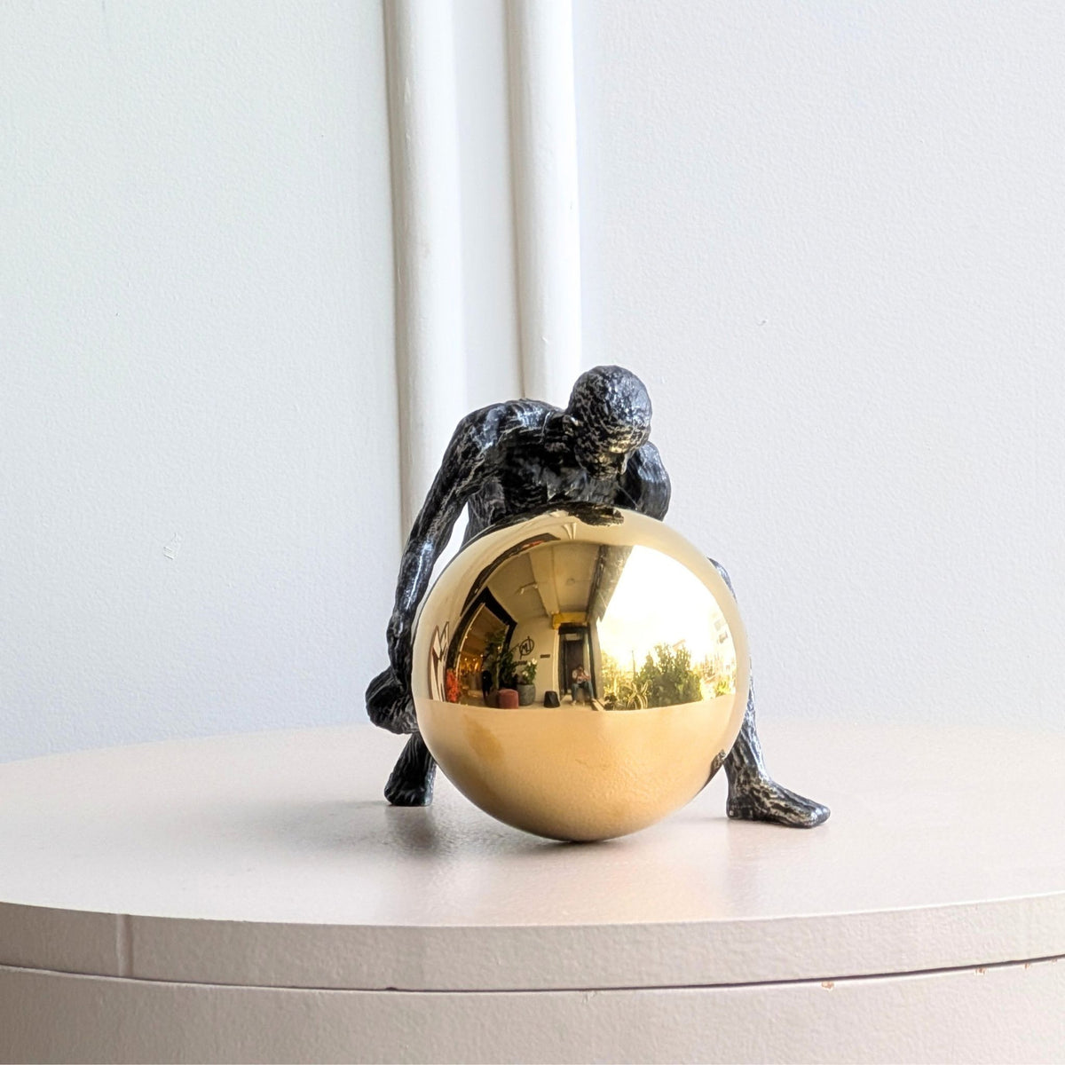 Strive dark textured metal showpiece with mirror gold orb, studio view
