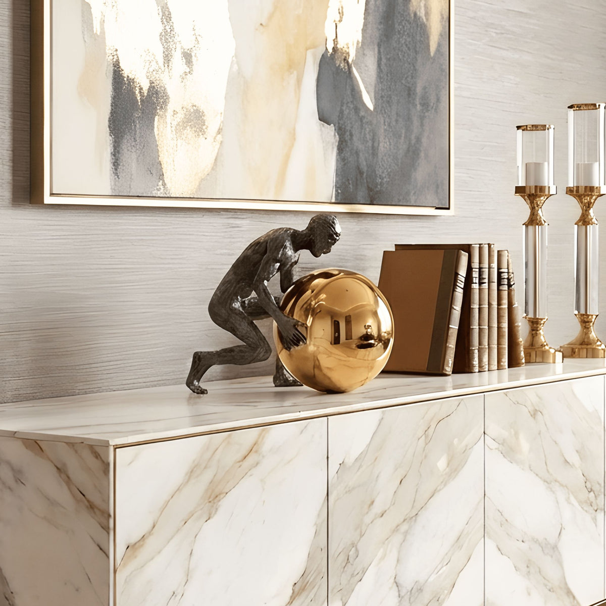 Strive human figure with gold sphere showpiece on a marble console beneath abstract artwork