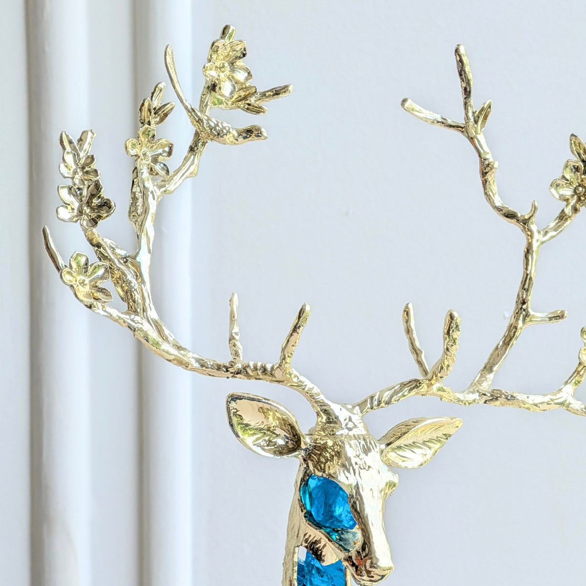Gold-toned antler and face detail of the Mystique sitting deer showpiece
