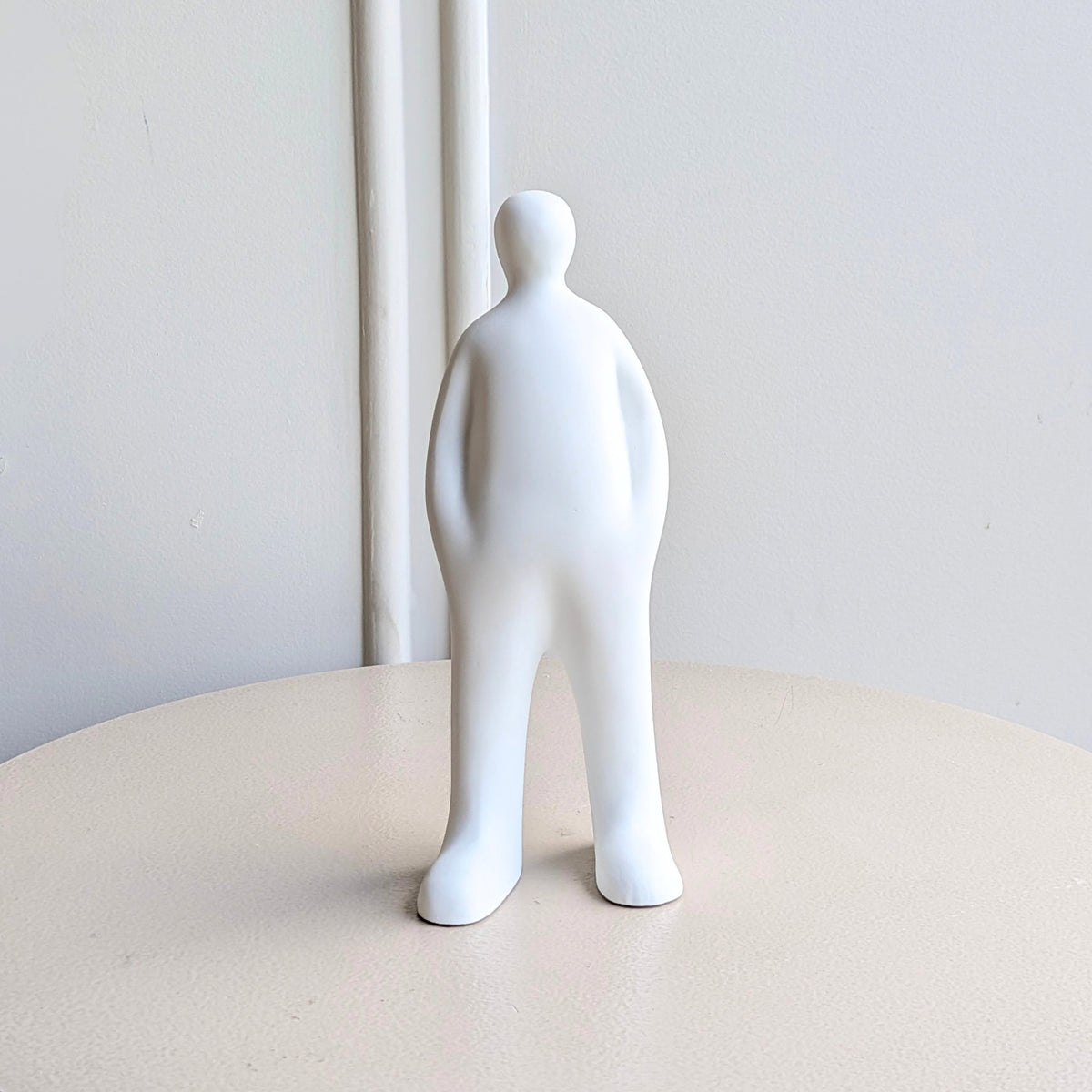 Off Duty White minimalist resin human figurine styled beside books