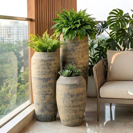 Patina ceramic floor pots styled with green plants on a modern balcony