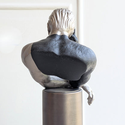 Rear detail of the Pensive sculptural human figurine and metal pedestal
