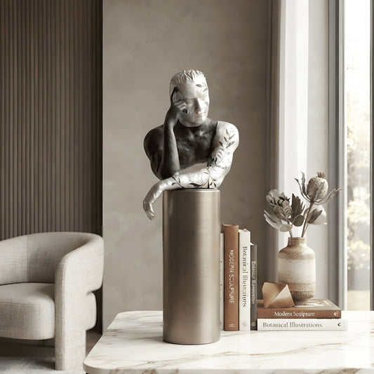 Pensive black and silver thinking man figurine styled on a marble console table