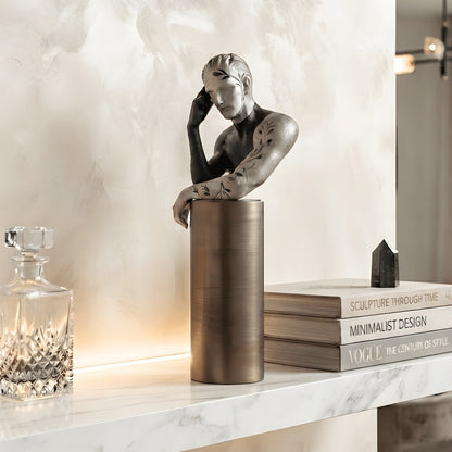 Pensive thinking man figurine styled with books on a marble sideboard