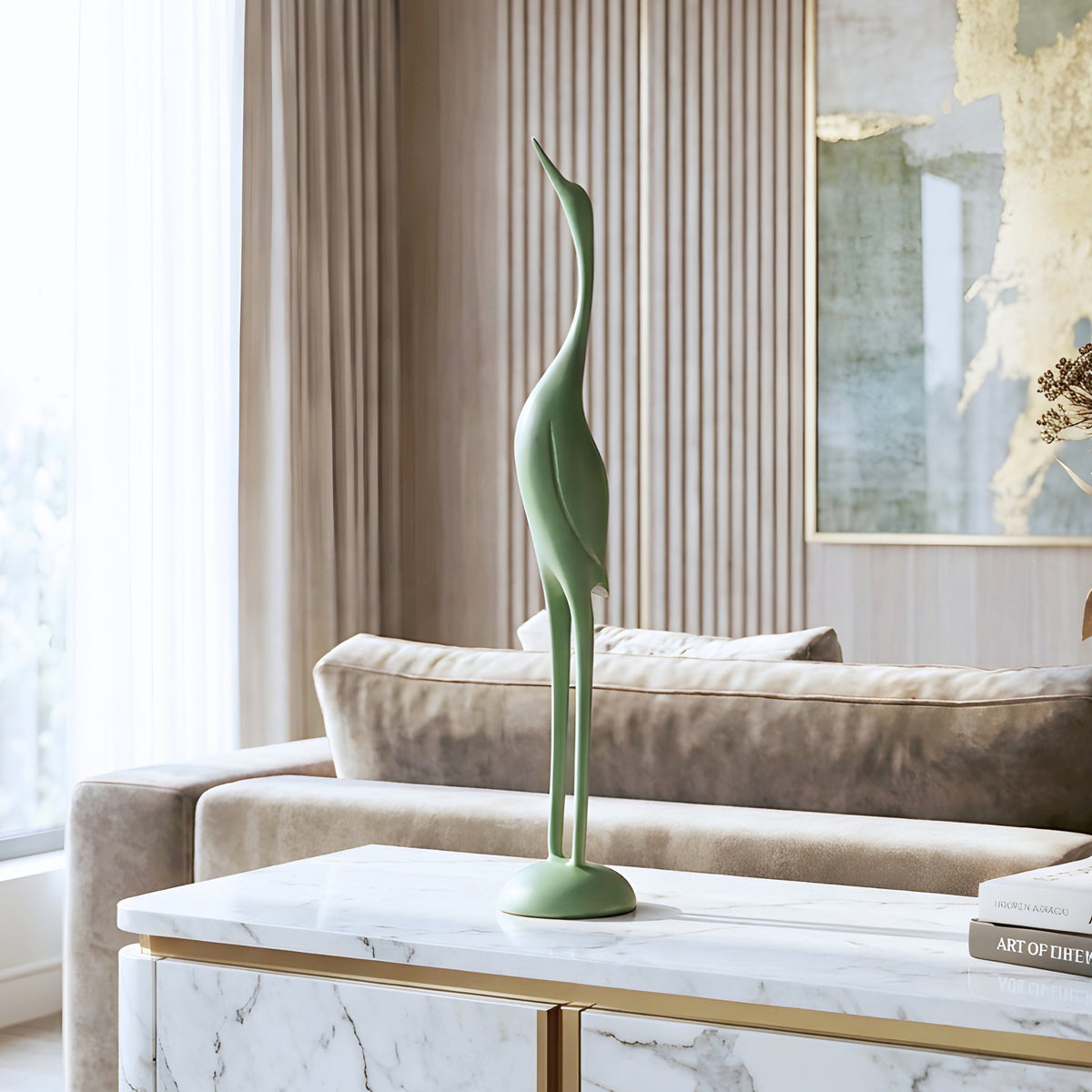 Tall mint green resin bird sculpture styled on a contemporary living room sideboard
